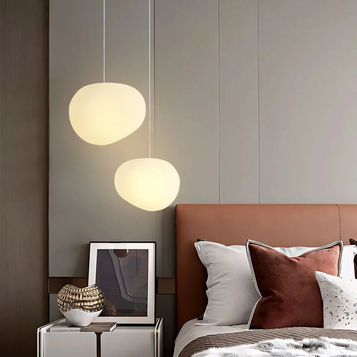White pebble pendant light, minimalist design, providing soft modern ambient ceiling light.