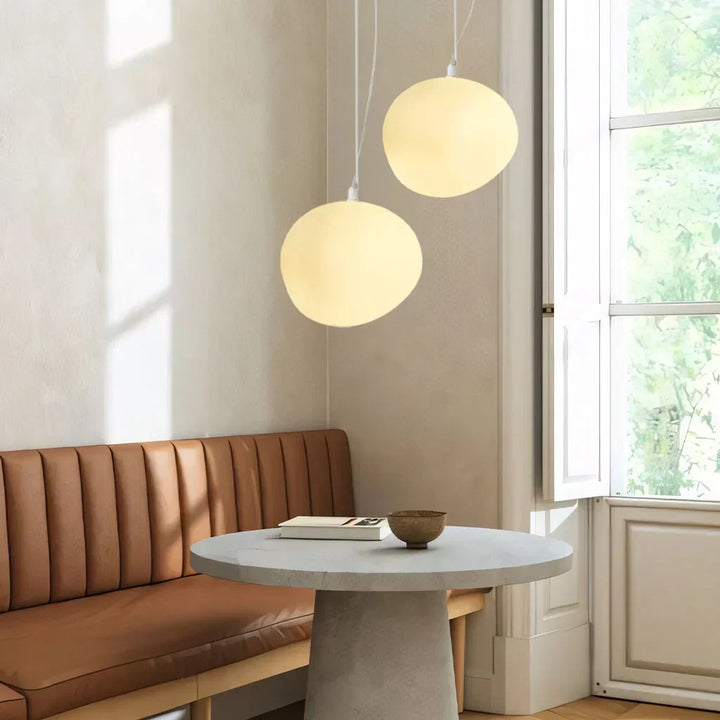 Minimalist white pebble pendant light providing ambient modern lighting for home decor.