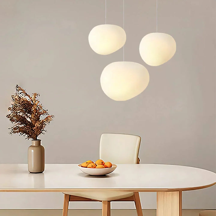 Contemporary white pebble pendant light, elegant minimalist ceiling lamp for modern interiors.