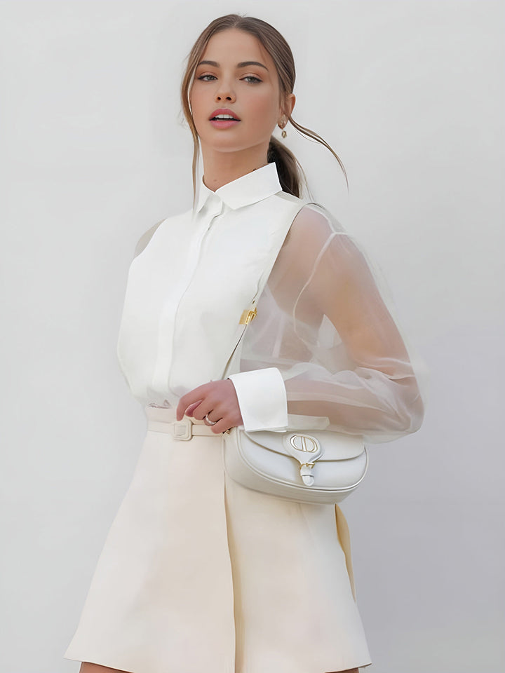 Chic white women's top featuring sheer long sleeves, a classic collar, and stylish button-front detail. Versatile apparel.
