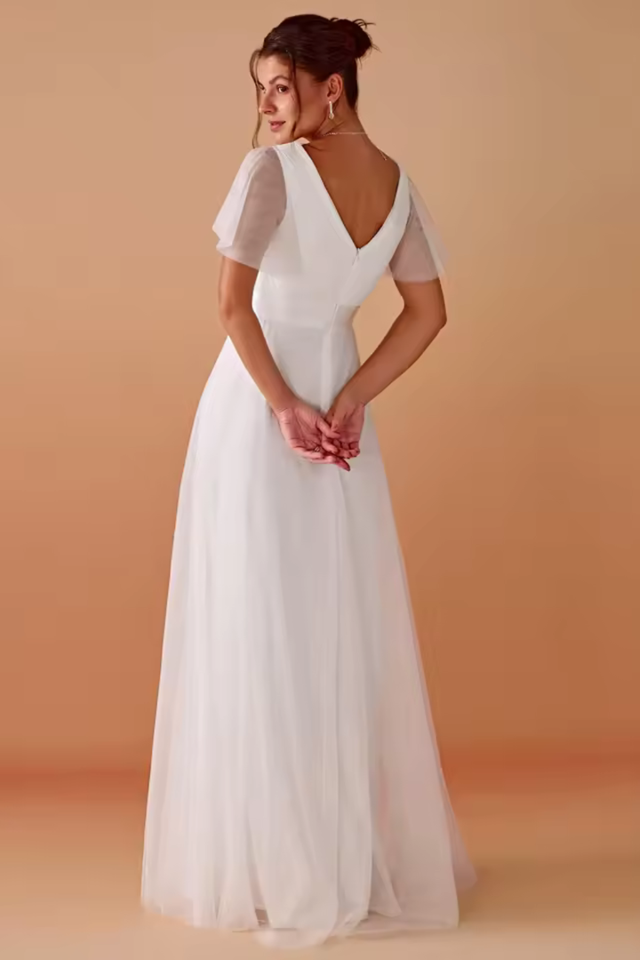 Full-length view of a women's white V-neck flutter sleeve maxi dress, an elegant choice for wedding guests.