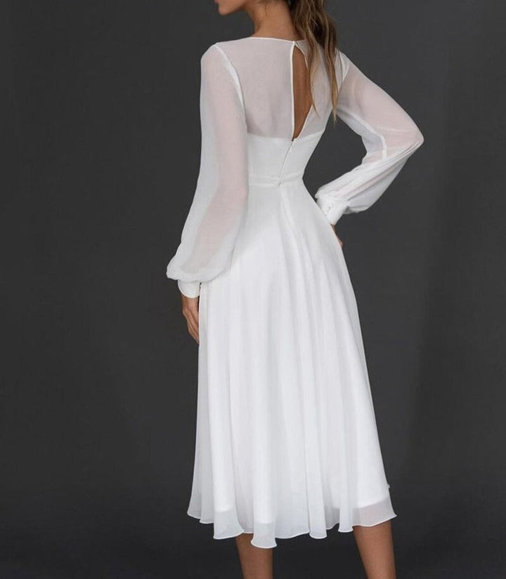 Women's flattering white V-neck midi dress with long sleeves & an elegant pleated skirt, ideal for evening parties.