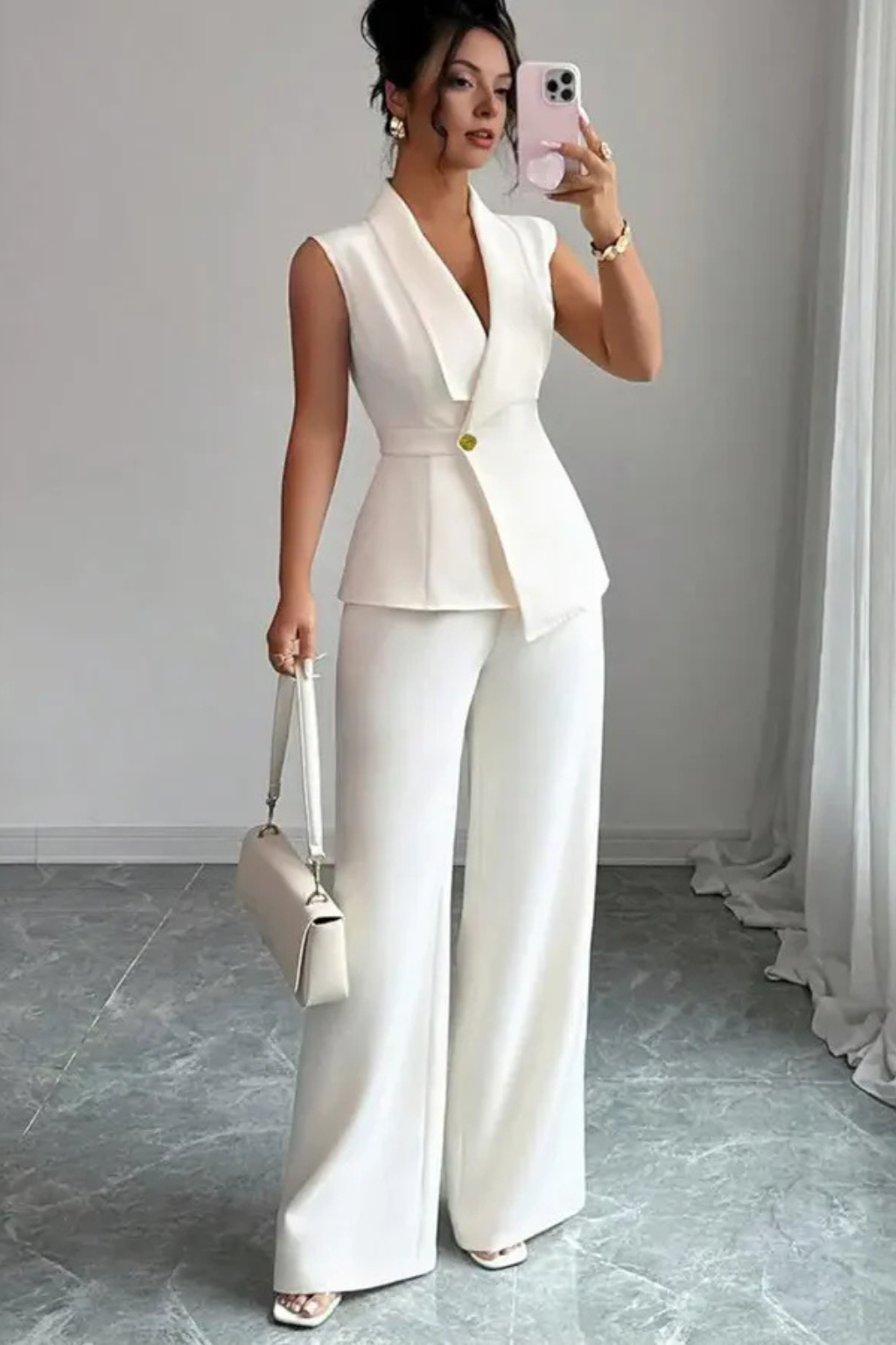 Women's white V-neck sleeveless blazer and wide-leg trouser suit. Versatile for office or elegant evening wear.