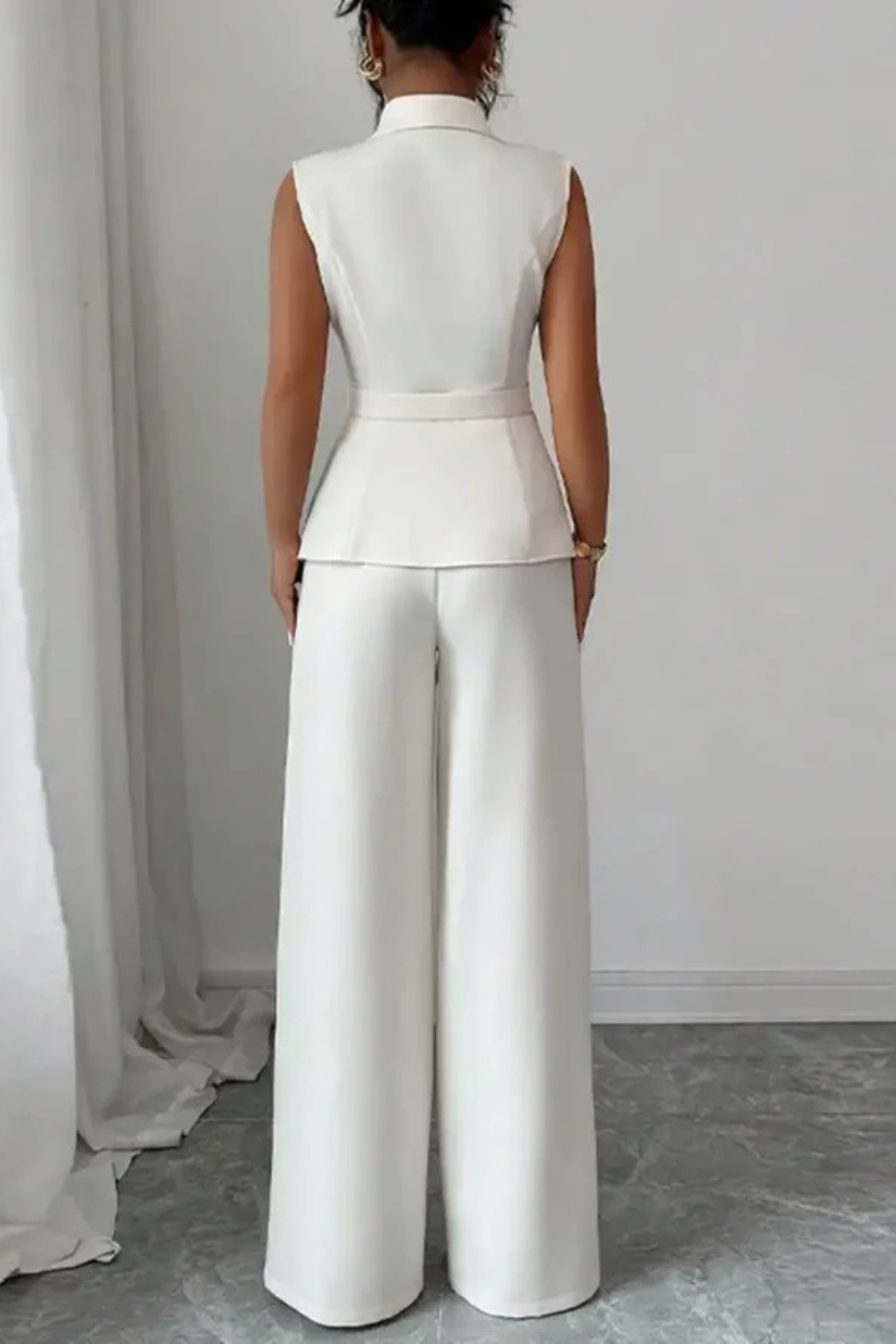 Fashionable white women's suit set: sleeveless V-neck blazer & wide-leg trousers. Sophisticated business outfit.