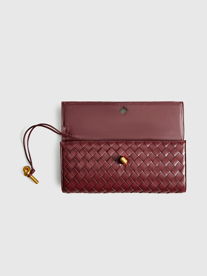 Model wears elegant wine red woven clutch & shoulder bag. Stylish women's versatile purse, perfect for any outfit.