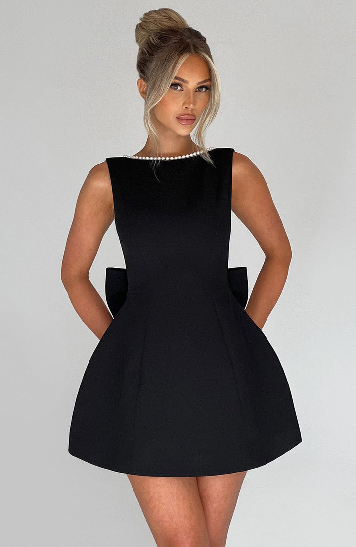 Stylish women's formal A-line mini dress with pearl trim, a perfect elegant summer party or wedding guest outfit.