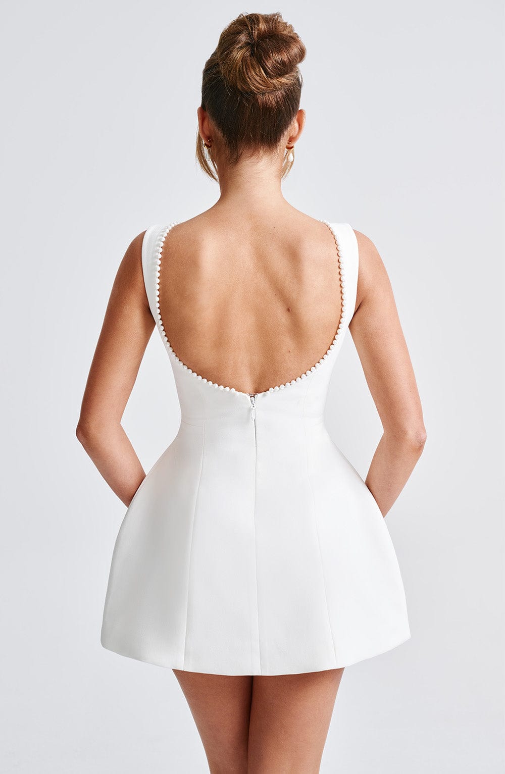 Elegant pearl trim A-line mini dress on a hanger, ready for a women's wedding, cocktail, or formal event.