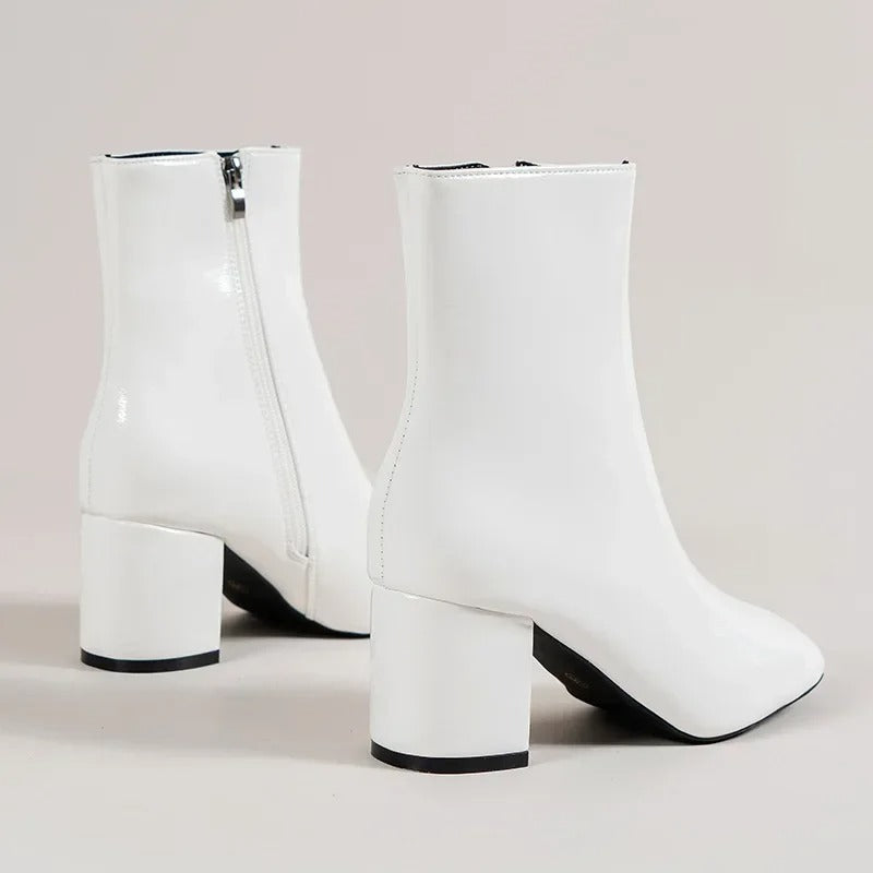Chic white women's ankle boots. Elegant pointed toe and sturdy block heel for versatile style.