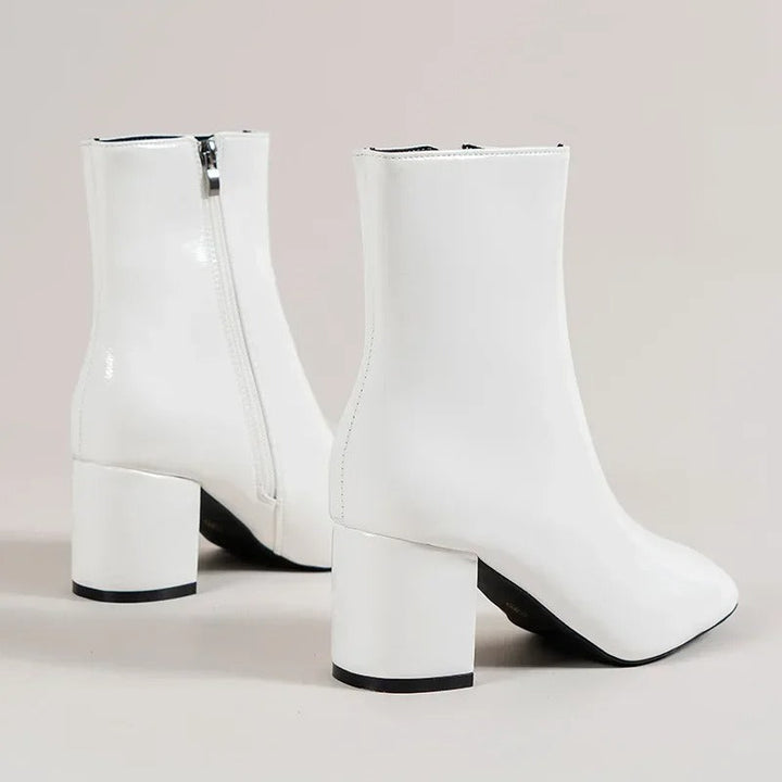 Chic white women's ankle boots. Elegant pointed toe and sturdy block heel for versatile style.