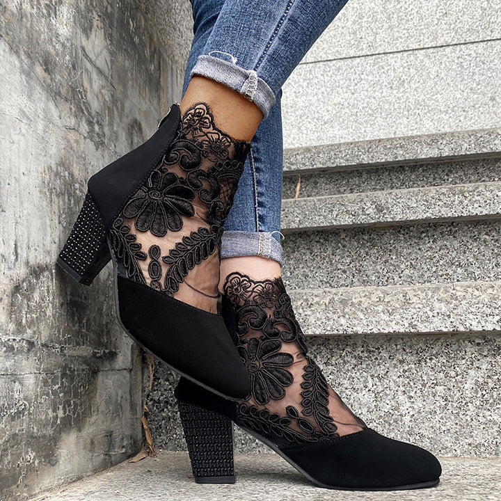 Side view of black women's ankle boots, showcasing delicate lace embroidery & a stable block heel. Fashionable.