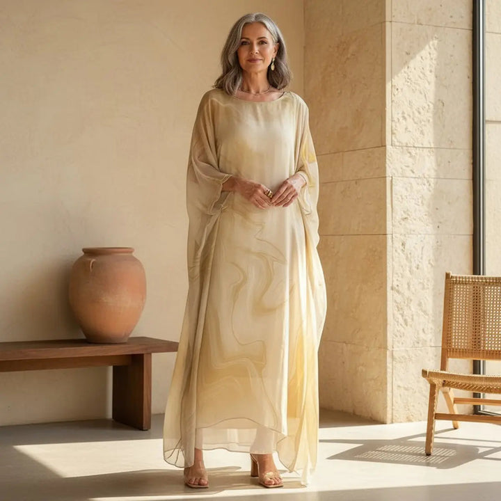 Graceful women's batwing maxi dress, a floaty long sleeve gown with a round neck for elegant evening wear.