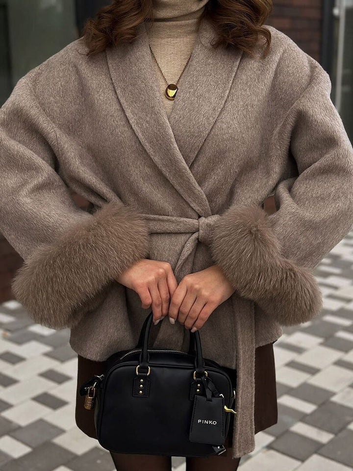 Elegant women's belted wrap coat with luxurious faux fur cuffs. Perfect for winter fashion.