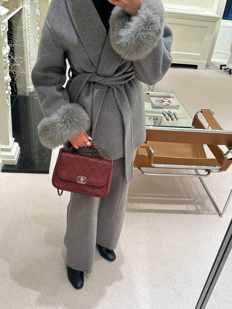 Women's designer wrap coat with a stylish belt, elegant shawl collar, and luxurious faux fur cuffs.