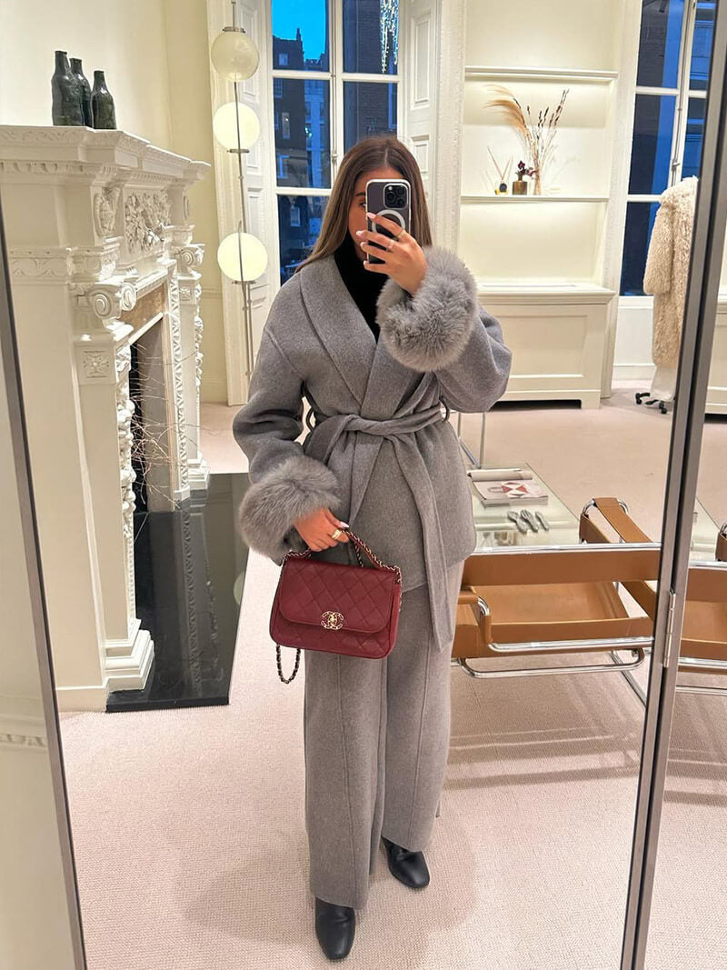 Plush faux fur cuffed women's wrap coat, belted for a flattering fit, ideal for winter luxury.