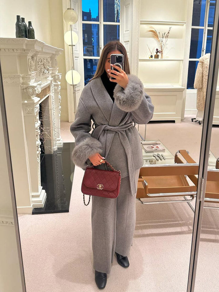 Plush faux fur cuffed women's wrap coat, belted for a flattering fit, ideal for winter luxury.