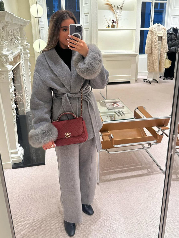 Glamorous women's belted wrap coat, featuring a luxurious faux fur trim on the cuffs.