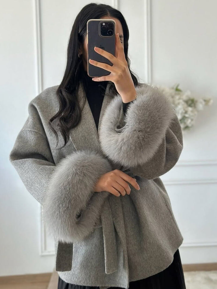Stylish women's wrap coat, featuring a tie belt & plush faux fur cuffs. Ideal for cold weather.