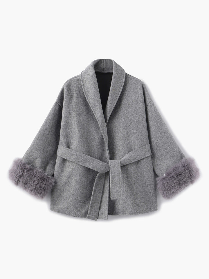 Fashionable women's belted coat, elegant shawl collar, and opulent faux fur sleeve details.