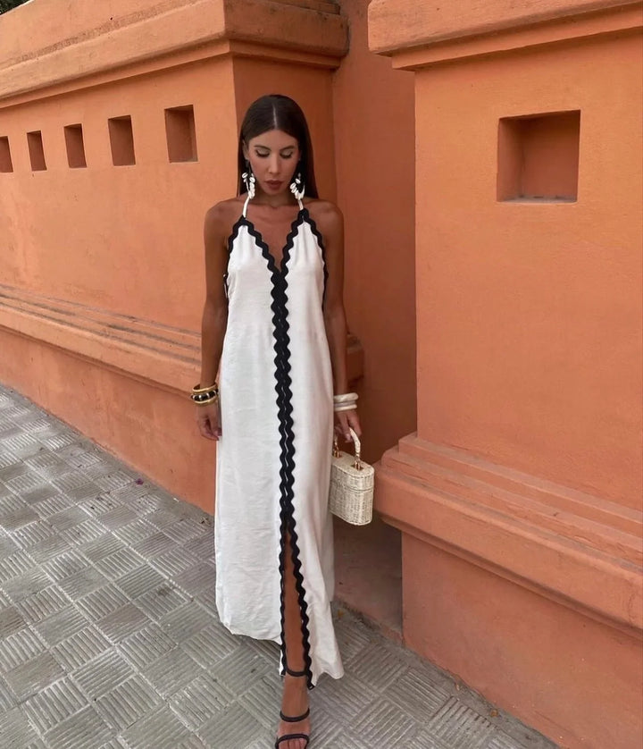 Chic black & white maxi wrap dress for women, featuring a stylish halter V-neck and scalloped details. Sleeveless.