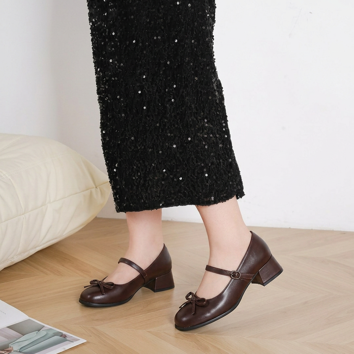 Elegant women's black Mary Jane block heels with a decorative bow, perfect for dressy occasions & classic style.