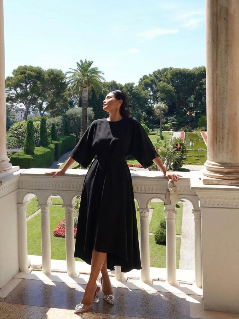 Sophisticated black formal midi dress with unique cape sleeves & elegant asymmetric silhouette. Ideal for special occasions.