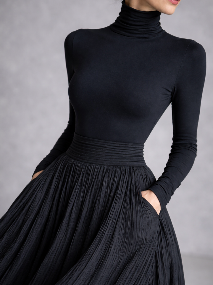 Stylish women's black pleated full skirt maxi dress with a warm turtleneck, ideal for evening fashion & events.