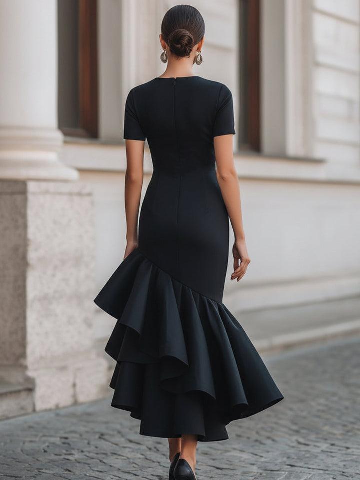 Flattering black tailored midi dress with graceful ruffles and a sophisticated fit, suitable for evening wear.