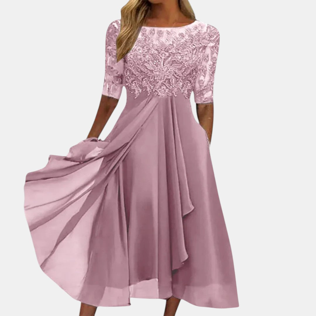 Close-up of the delicate lace detail on a women's cream formal occasion dress, elegant and flowing.