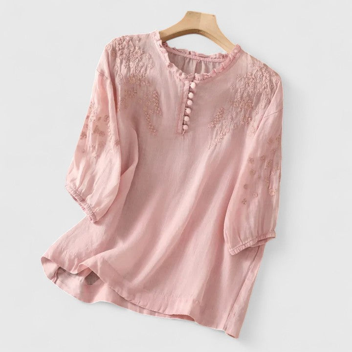 Elegant women's button-front blouse with intricate floral embroidery, perfect for stylish workwear or casual chic outfits.