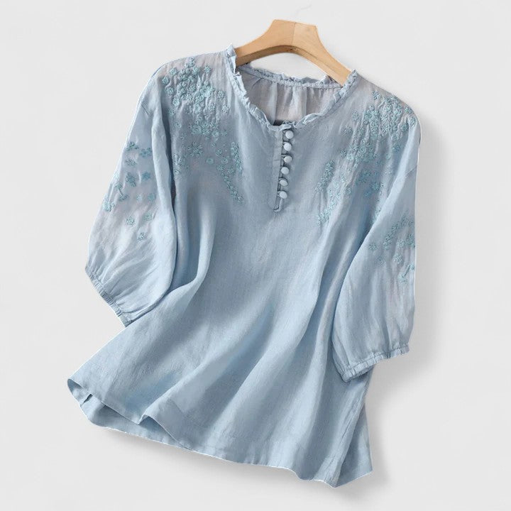 Fashionable women's button-front blouse with delicate embroidery detail, ideal for elegant casual wear or work.