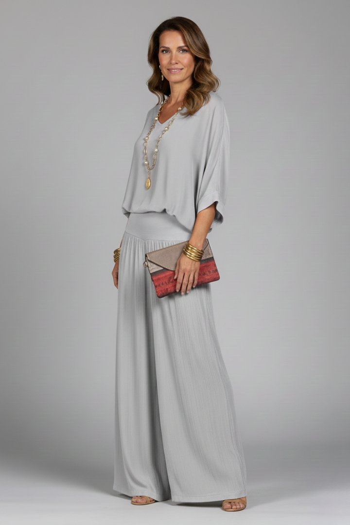 Full length view of a model wearing an elegant women's chiffon two-piece wide-leg outfit.