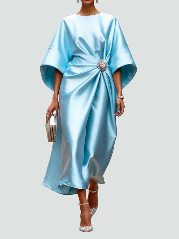 Sophisticated women's draped maxi dress featuring a stylish brooch, great for evening wear.
