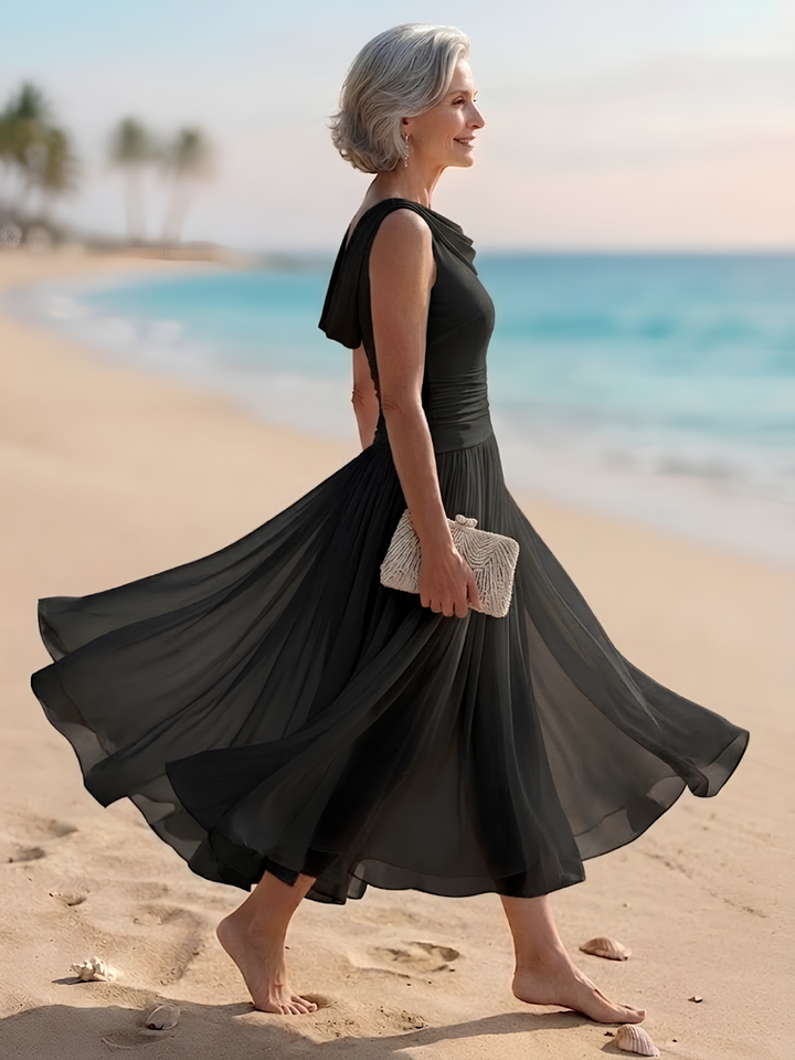Stylish women's wedding guest midi dress with a beautiful draped neckline & flowing pleated A-line silhouette.