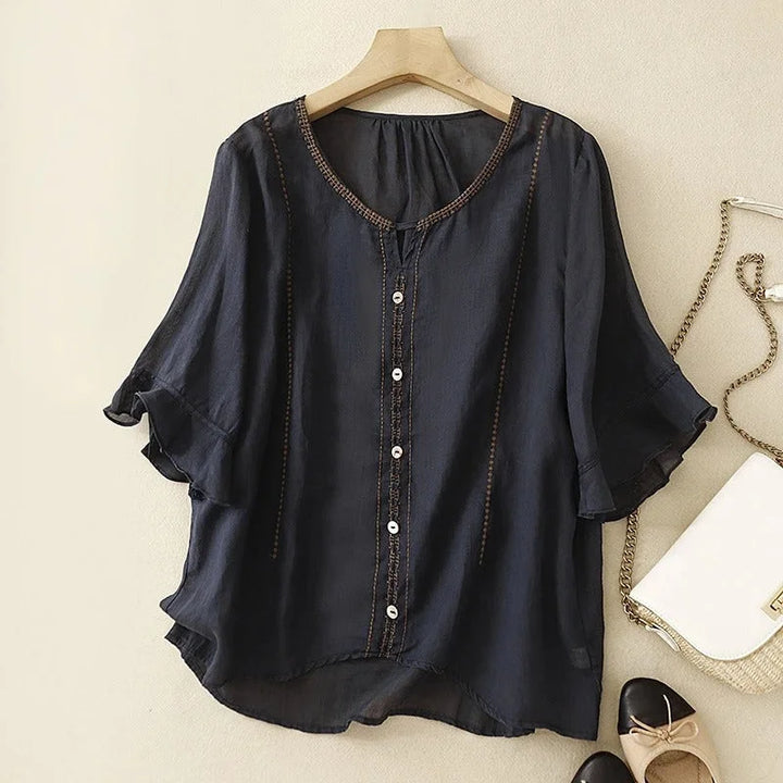 Detailed view of an elegant women's V-neck embroidered blouse, showcasing the ruffled 3/4 sleeves and buttons.