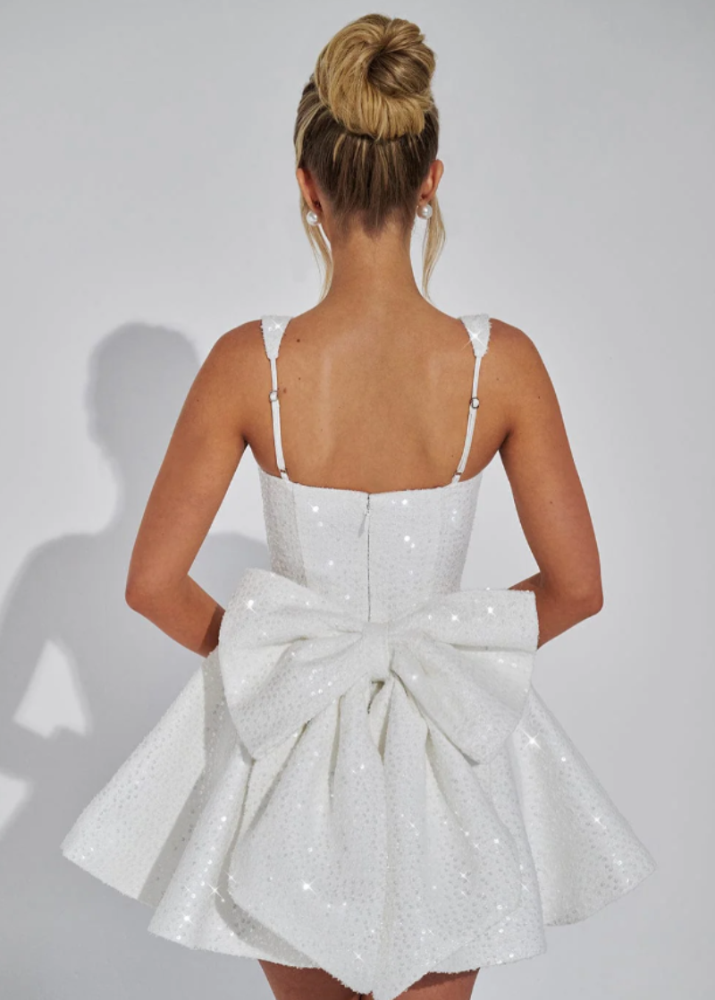 Trendy women's flared mini dress with a fashionable bow accent, great for modern occasion wear.