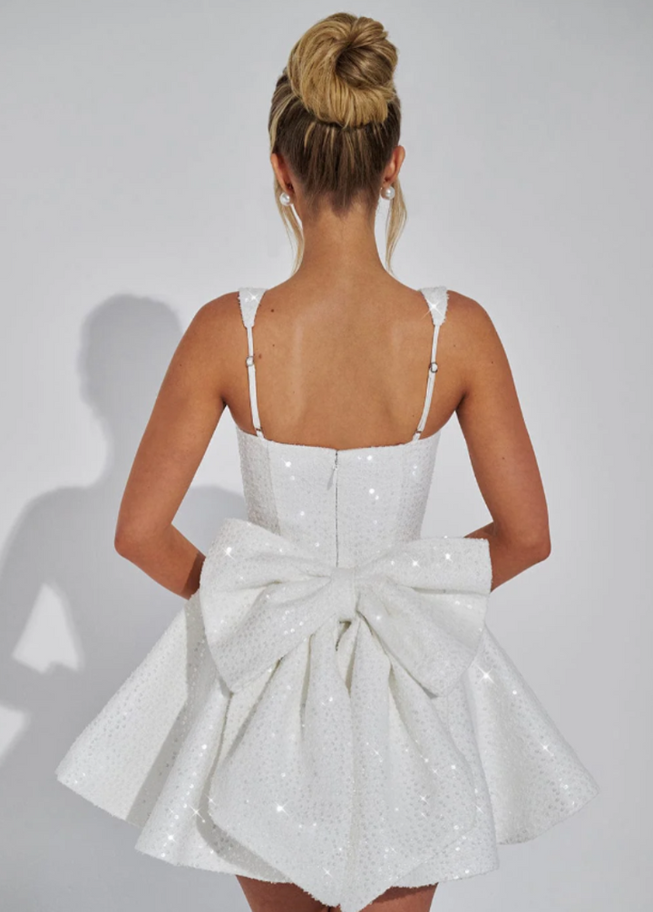 Trendy women's flared mini dress with a fashionable bow accent, great for modern occasion wear.