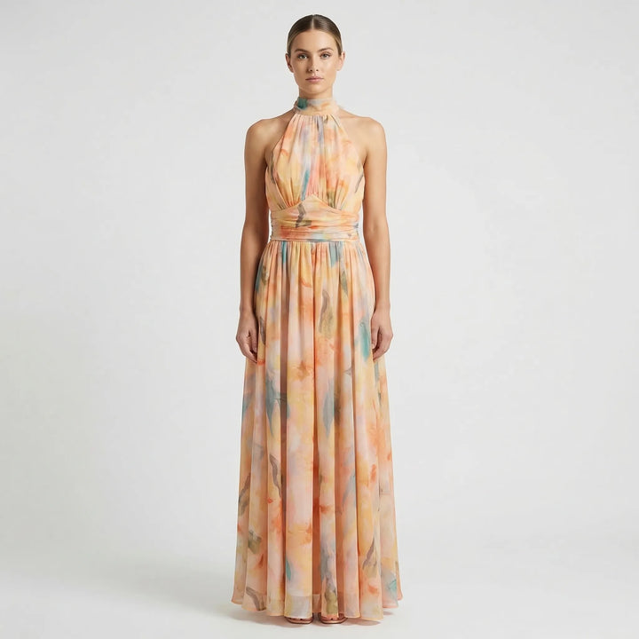 Peach coral floral halter-neck maxi dress for women, featuring a stylish open back and flowy summer design.