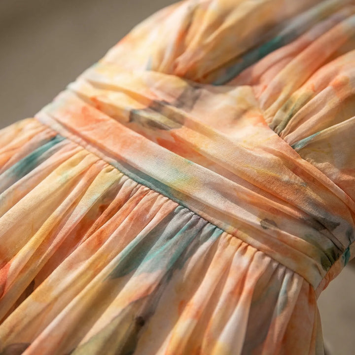 Women's sleeveless floral maxi dress in peach coral. Elegant halter-neck summer dress, ideal for fashion-forward style.