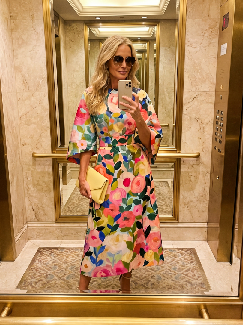 Back view of a women's elegant floral midi dress, highlighting wide sleeves and a flattering silhouette.