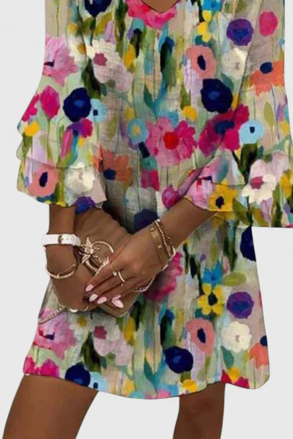 Vibrant multicolored floral print mini dress for women, featuring a flattering v-neck. Feminine summer party wear.