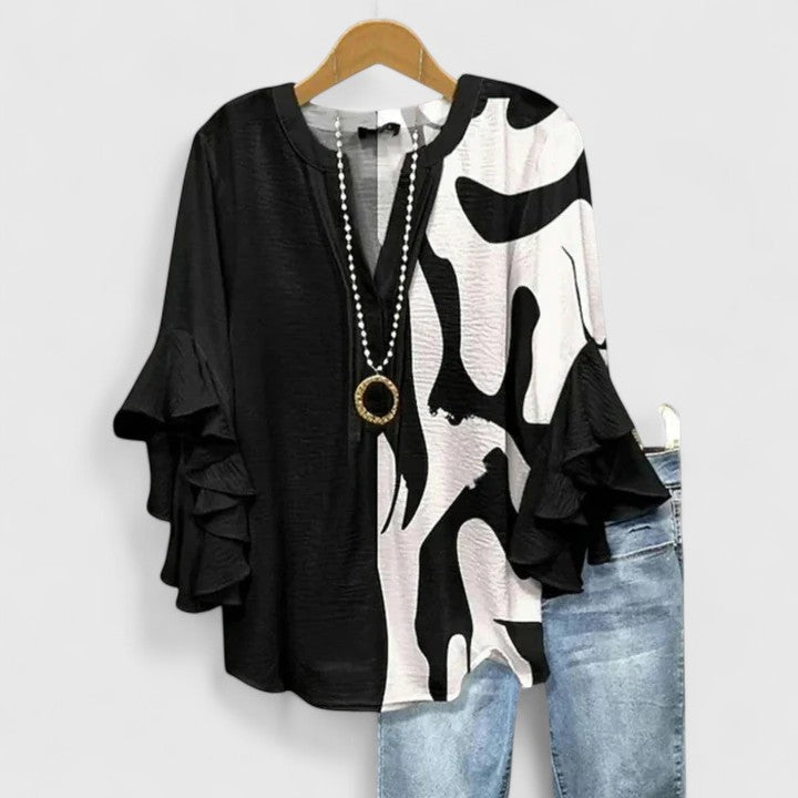 Fashionable women's blouse, intricate floral print, elegant ruffle sleeves. A versatile chic top.