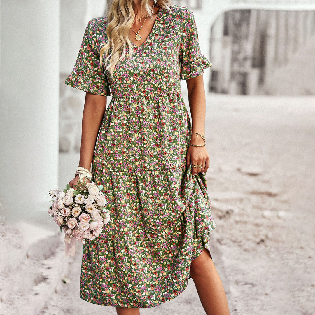 Stylish women's midi dress featuring a vibrant floral print, V-neck, and short sleeves, great for summer fashion.