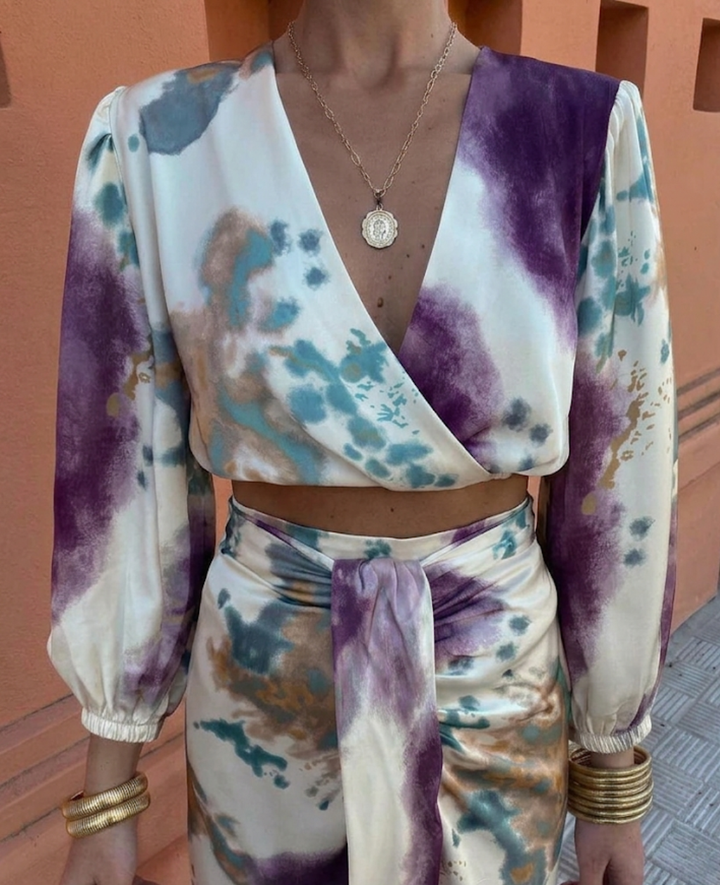 Women's chic floral print summer blouse and matching midi skirt two-piece set. Elegant and versatile fashion outfit.