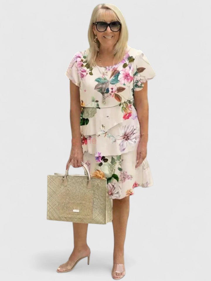 Chic women's tiered dress with vibrant floral print, comfortable & elegant for summer fashion.
