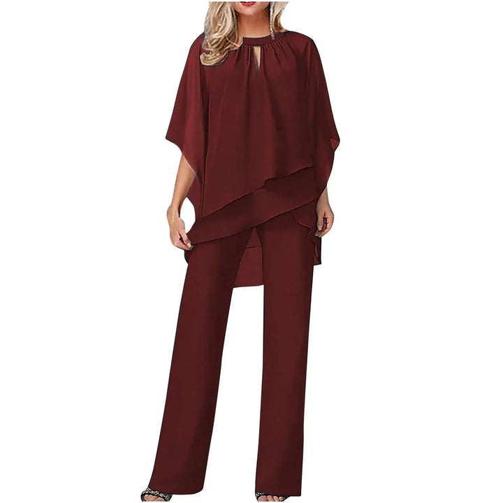 White women's dressy pantsuit with a flowing batwing-sleeve top and elegant wide-leg pants. Versatile for events.