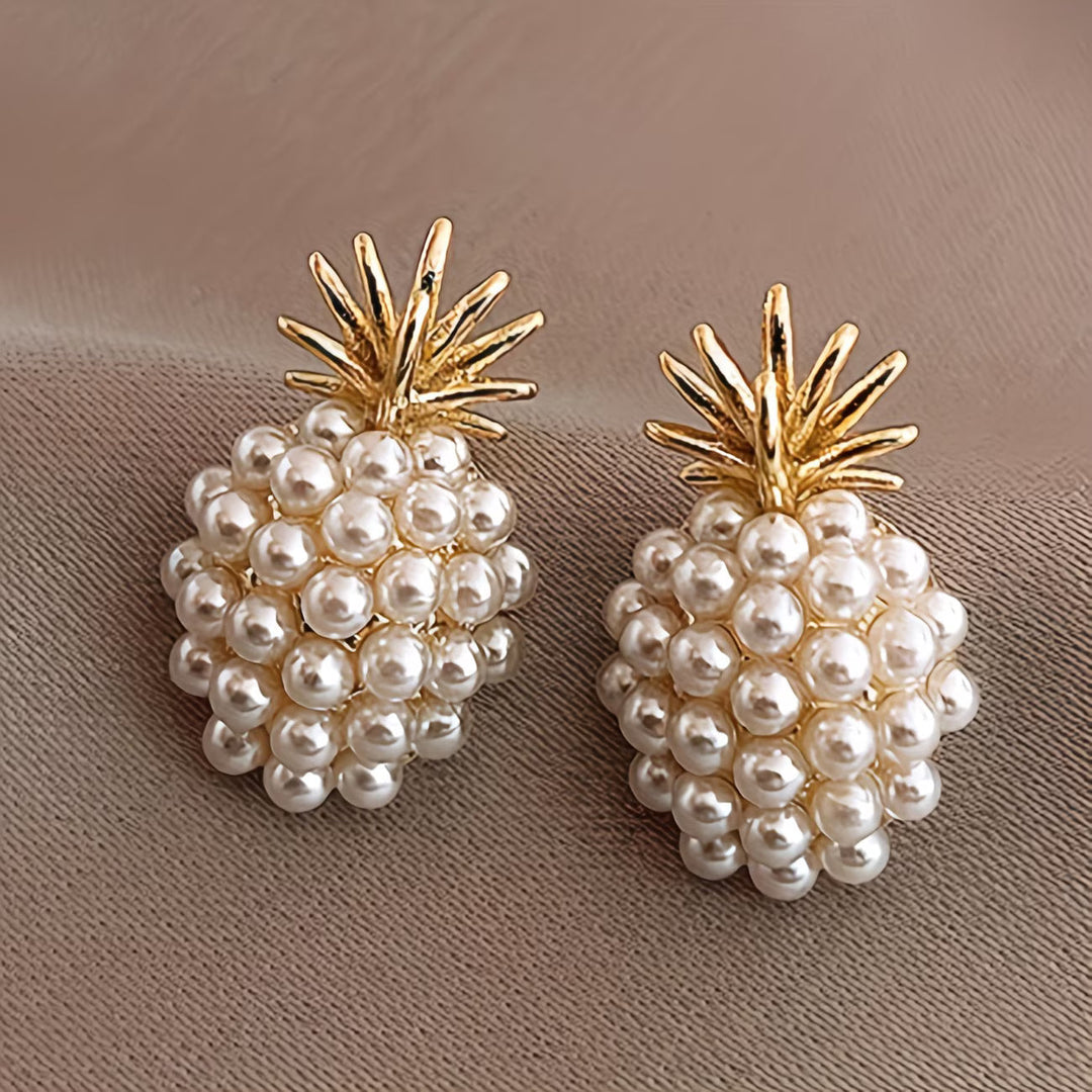 Elegant women's gold pineapple and lustrous pearl drop earrings, a perfect tropical fashion jewelry accessory.