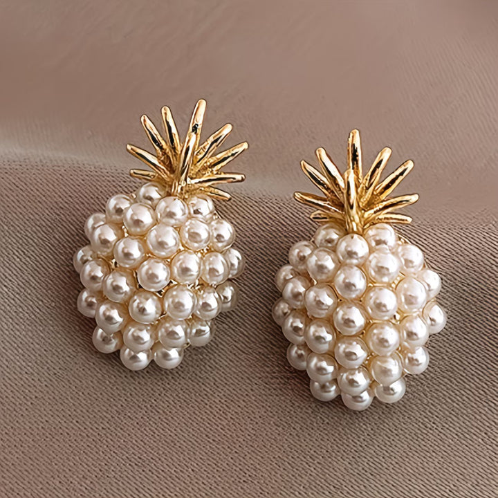Elegant women's gold pineapple and lustrous pearl drop earrings, a perfect tropical fashion jewelry accessory.