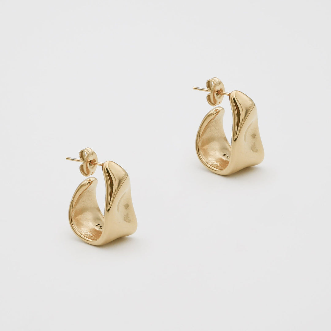 Close-up of unique textured half hoop earrings for women, crafted in beautiful gold & silver.