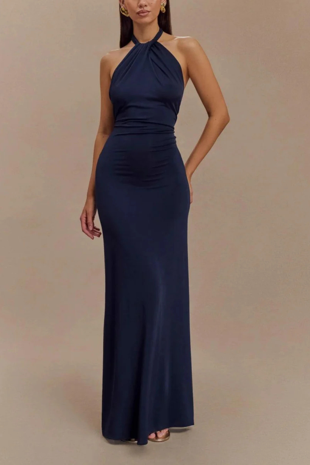 Long women's halter neck bodycon maxi dress. Open back & ruched design for elegant wedding guest attire.