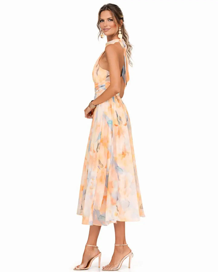 Sleeveless women's halter neck floral midi dress. Elegant summer occasion wear with a vibrant print.